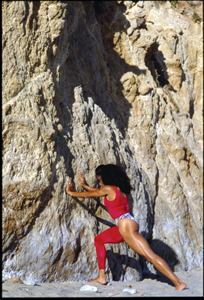 Florence Griffith Joyner stretching against cliffs in a photograph by portrait photographer, Steve Landis